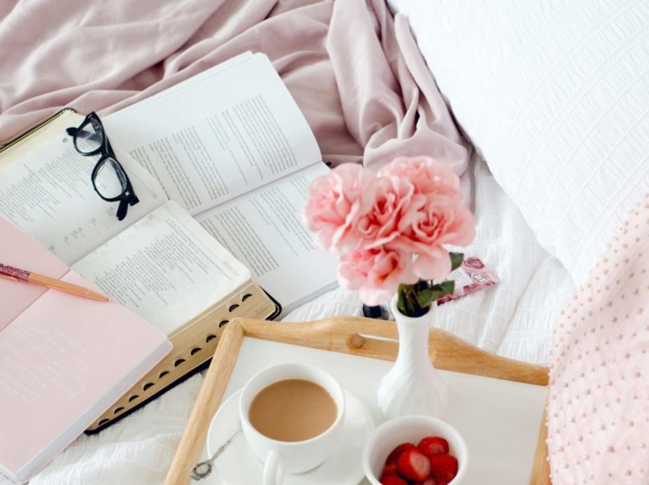 Inviting breakfast in bed scene with coffee, pancakes, and blooms, perfect for cozy mornings.